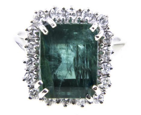 An emerald and diamond rectangular cluster ring, one step cut emerald 12.4mm x 9.5mm x 8.3mm, four double claw set and surrou