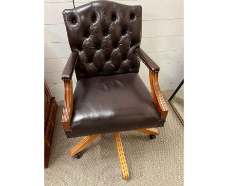A leather captain style office desk chair with button back and swirl base 