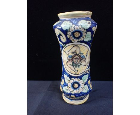 A FAIENCE ALBARELLO JARpainted with a three-legged winged head, in a cartouche within scrolling foliage 27cm high (chips to g