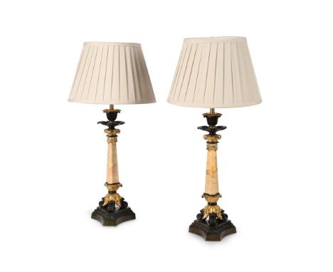 A PAIR OF MARBLE AND BRONZE TABLE LIGHTS  FRENCH, LATE 19TH CENTURY AND LATER  The swept triform candlestick bases with ormol