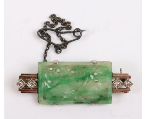 An Art Deco 18ct platinum mounted jade and diamond brooch, central foliate and bird carved jade panel, within a stepped recta