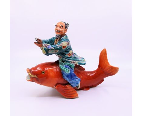 A Japanese pottery fisherman straddling a&nbsp; carp