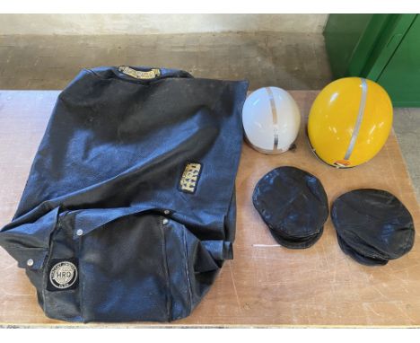 Two leather caps with assorted enamel motorcycling badges attached, plus two helmets, one 1970s Kango, both for display purpo