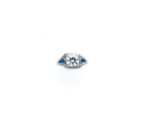 DIAMOND RING, 1920s the Art Deco ring set with a circular diamond in a pierced scroll and millegrain mount between calibré-cu