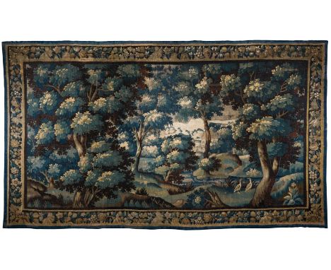 A VERDURE TAPESTRY, FLEMISH, LATE 17TH CENTURY  woven in wools and silks with a wooded landscape featuring a stream and a cha