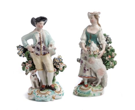 TWO DERBY FIGURES OF A SHEPHERDESS AND A SHEPHERD, CIRCA 1770 each standing before a flowering tree with a dog or a lamb resp