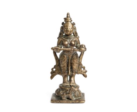A BRASS FIGURE OF ANNAPURNA, DECCAN, SOUTHERN INDIA, 18TH/19TH CENTURY standing on a lotus base, a diminutive lion at her fee