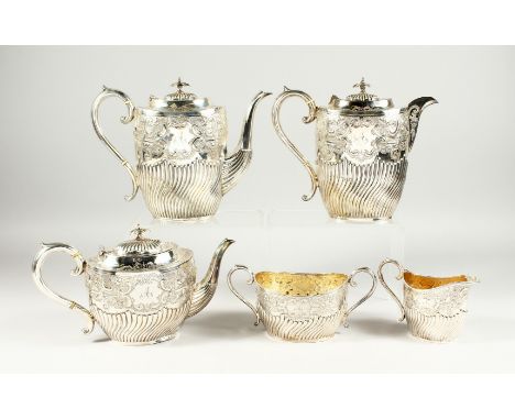 A VICTORIAN SILVER FIVE PIECE TEA SET a with scroll and repousse decoration. Initialed A. Comprising tea pot, two hot water j