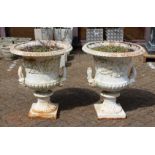A GOOD PAIR OF VICTORIAN WHITE PAINTED CAST IRON CAMPAGA VASES with mask handles on square bases.