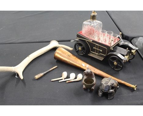 Works of art, consisting of a novelty decanter and shot glass set in the form of a car, copper horn, three clay pipes, carved