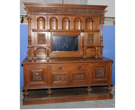 Extremely large late Victorian light oak dresser with raised back with heavily carved cornice above concave panels, two cupbo