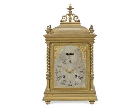 A late 19th Century gilt brass mantel clockWith a silvered dial, black Roman numerals and a blind pendulum aperture flanked b