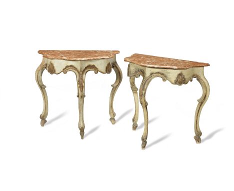 A pair of cream and gilt painted console tablesAustrian, 18th century The serpentine shaped marble tops with moulded edges ab