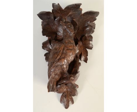 A German Black Forest bracket carved with a bird perched amid leaves, height 28.5cm, together with a wooden cribbage board.