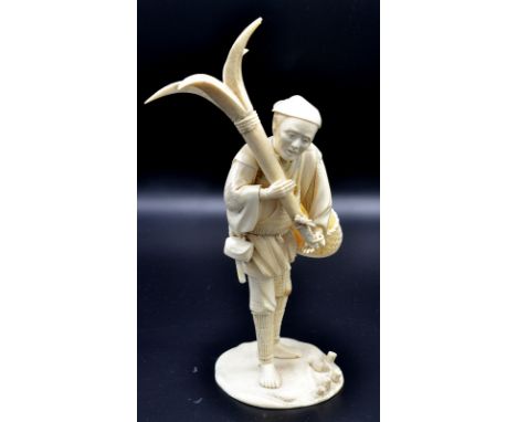 A Japanese ivory okimono, a fisherman standing holding a four bladed anchor, attached to his sash a fish basket. Late Meiji. 