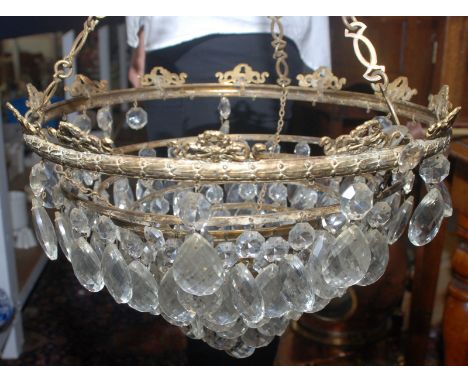 A brass, five tier lustre hung chandelier with a box of spare lustres.