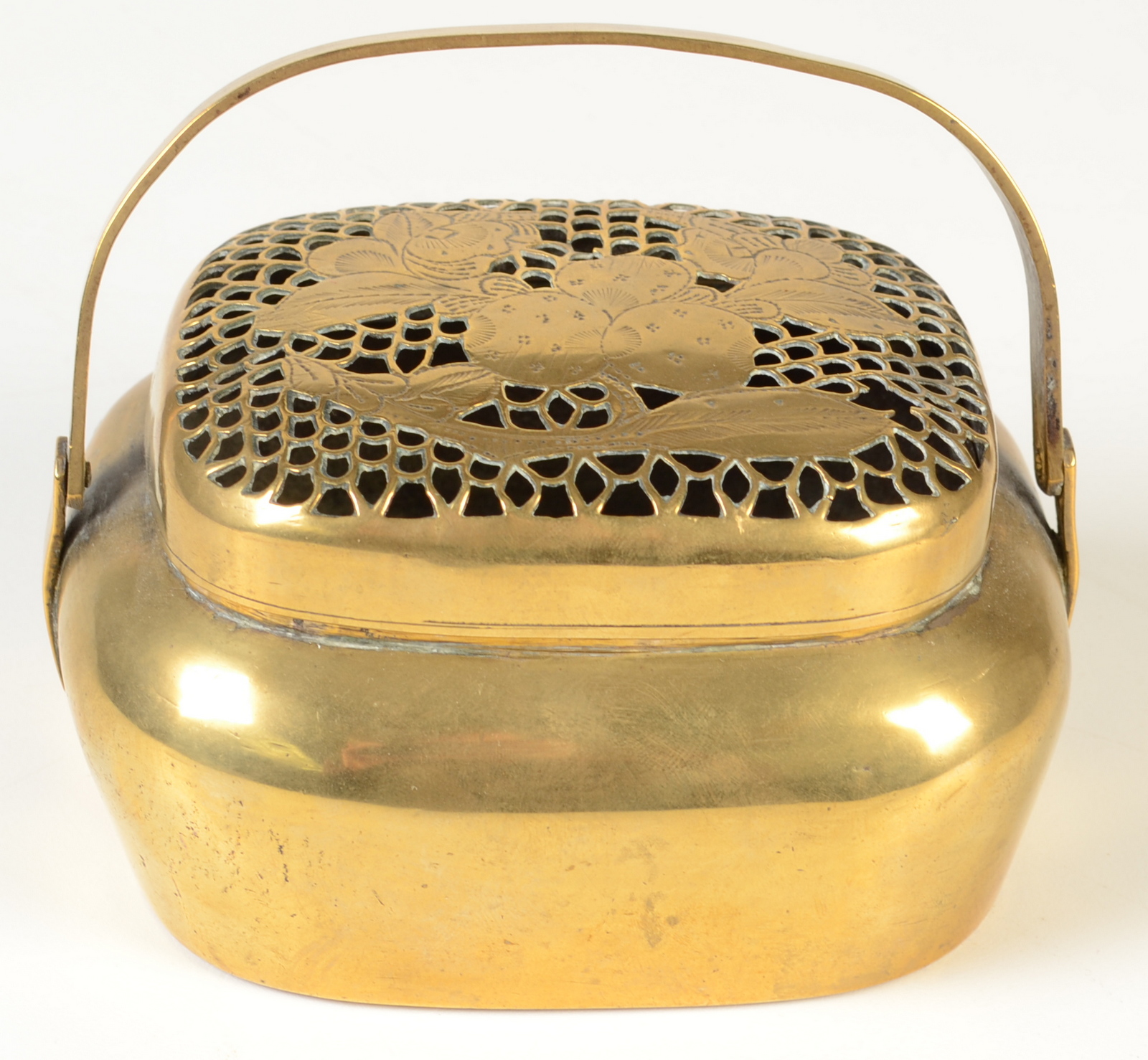 An oriental metal hand warmer, the pierced cover decorated with