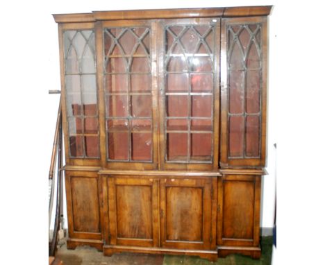 A walnut veneered break front bookcase in 18th century style with bracket feet, the upper section with glazed doors, width 17