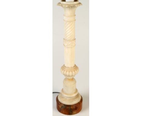 An alabaster table lamp made as a classical column with a lotus flower capital and a fabric shade.