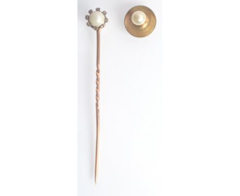 A gold pin with a screw in half pearl finial surrounded by tiny diamonds, boxed with a single stud. 