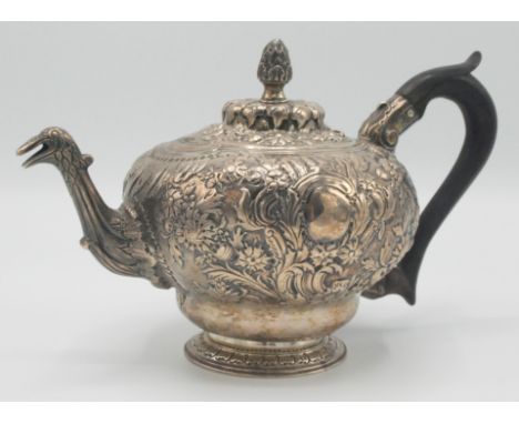 An 18th century ornate continental silver teapot with birds head spout and fir cone finial. Indistinct marks to base, possibl