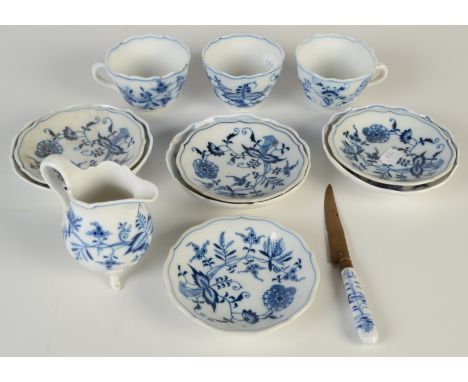 A Meissen 'Onion' pattern cream jug, together with seven similar saucers, three cups and a knife.