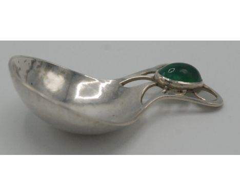 An Arts and Crafts pierced silver caddy spoon with a greenstone oval cabochon, in the manner of Archibald Knox.   Condition r