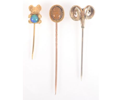 A gold tiger eye scarab beetle pin, a modern 9ct gold craft pin the finial a rams head and one other pin. 