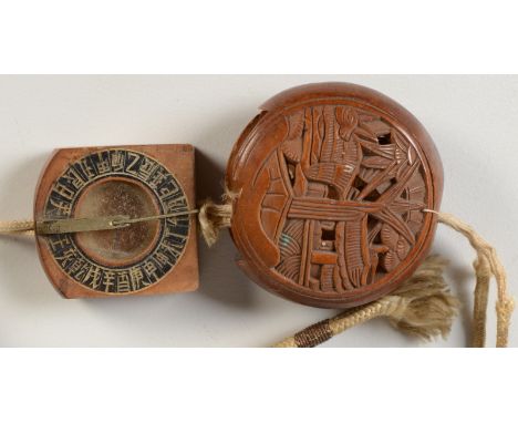 A Japanese carved wood Manju netsuke, decorated to one side with a pavilion and trees, to the other with palm leaves, fitted 