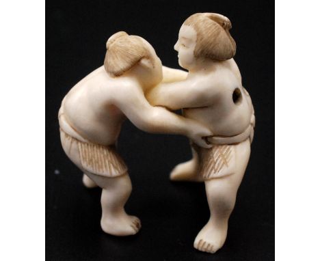 A Japanese ivory netsuke, two Sumo wrestlers standing facing each other, signed on one footKoichi?  Showa 4cm.