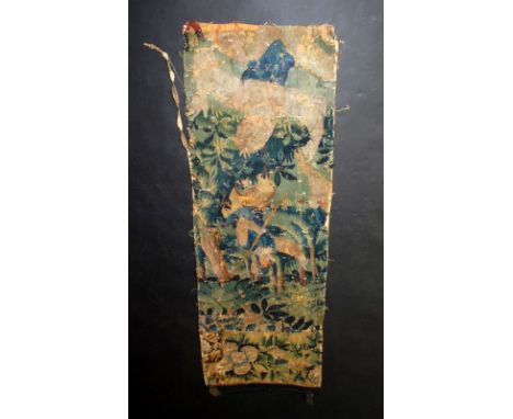 A 17th century Flemish tapestry fragment of a woodland scene with a lady dancing in the foreground and a gentleman with a sta