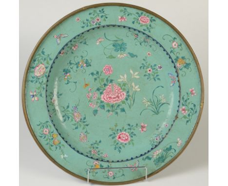 A Chinese Canton enamel salver decorated with a central peony motif surrounded by symbolic flowers and foliage, the broad rim