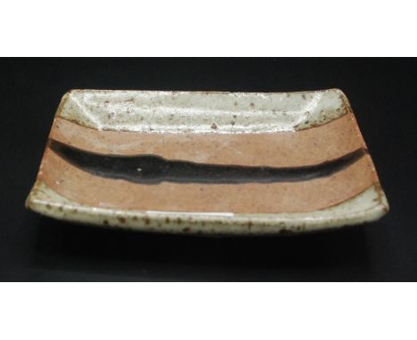 Janet Leach, St Ives Pottery, a small rectangular dish with a trail of tenmoku glaze, standing on four feet, impressed JL and