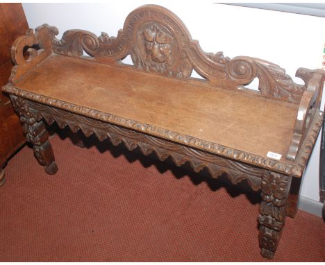 A carved light oak hall bench.