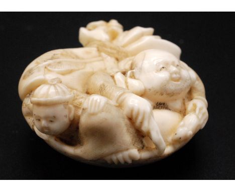 A Japanese ivory netsuke, a bowl decorated with etched designs of waves, Mount Fuji, boats and a river scene, a house amidst 