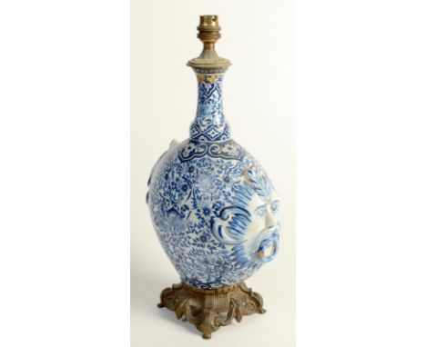 A European faience, blue and white pottery pilgrim flask, converted to a lamp base, the floral decorated body with grotesque 