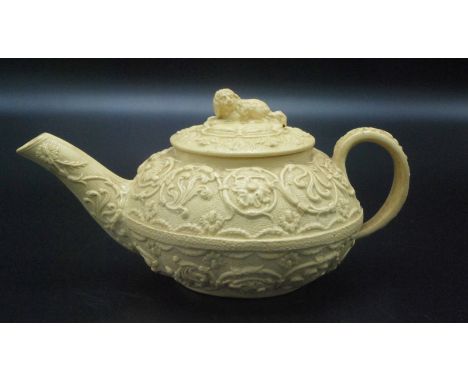 A Wedgwood early 19th century creamware bachelor's teapot moulded with flowers, the lid with a crouching dog finial, height 8