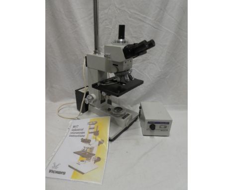 A Vickers M17 binocular microscope with lamp unit and instructions
