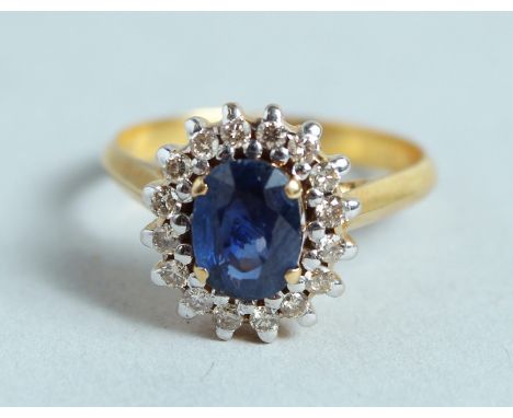 A GOOD 18CT GOLD SAPPHIRE AND DIAMOND CLUSTER RING.