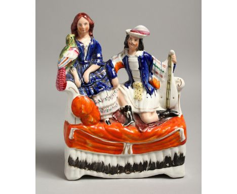 A STAFFORDSHIRE FLAT BACK GROUP, two figures on a sofa. 12ins high.