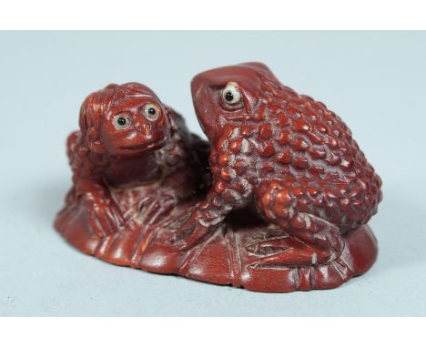 A JAPANESE WOODEN FROG NETSUKE.