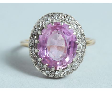 A PINK SAPPHIRE AND DIAMOND CLUSTER RING.