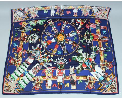 AN HERMES SILK SCARF, puppet and toy on a blue ground. 34ins x 334ins in a Hermes box.