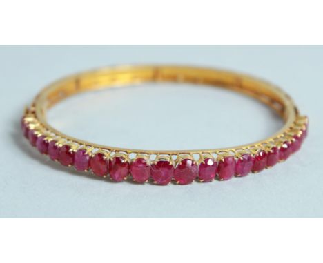 A GOOD 18CT GOLD RUBY SET BANGLE.