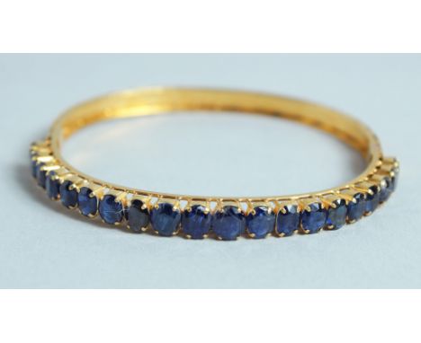 A GOOD 18CT GOLD SAPPHIRE SET BANGLE.