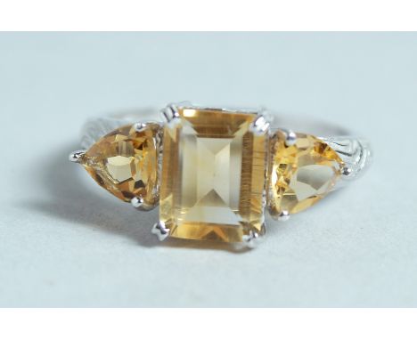 A SILVER AND CITRINE THREE STONE RING.