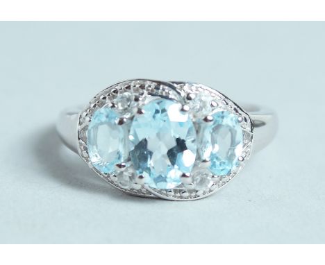 A SILVER AND AQUAMARINE THREE STONE RING.