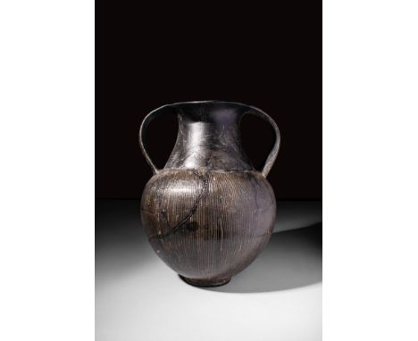 South Etruria, Cerveteri or Veio, Ca. 650 - 640 BC.An Etruscan bucchero nikosthenic amphora with engraved vertical lines in t