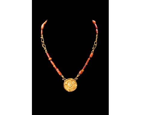 Ptolemaic Period, Ca. 332 - 30 BC.A Ptolemaic period carnelian necklace crafted from dozens of red tube beads alternating wit