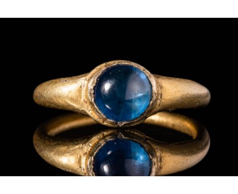 Ca. AD 100 - 300. A Roman gold ring. The round banded ring has a sapphire cabochon and is set in a gold frame. For similar se